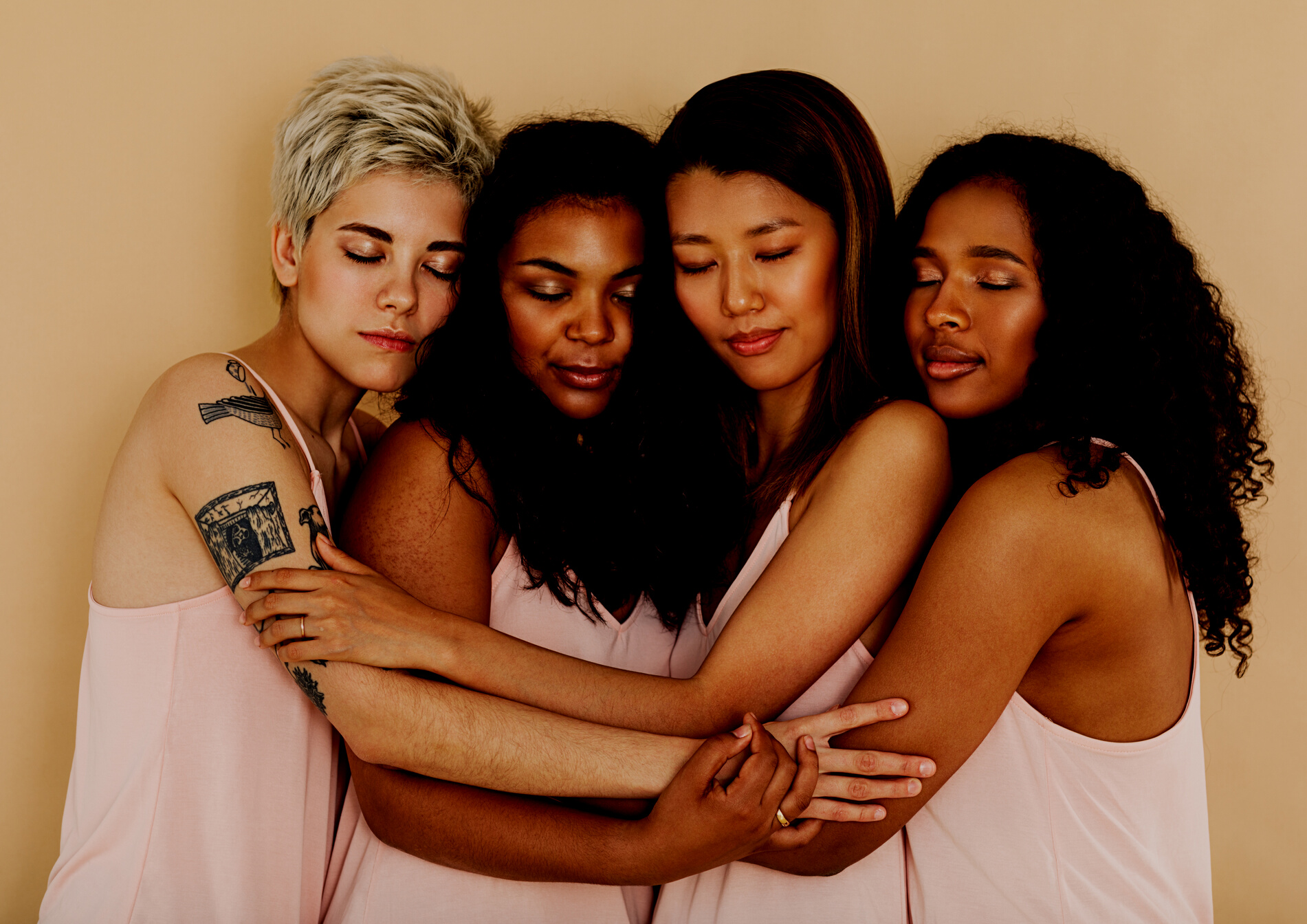 Diverse group of women in casuals standing together with eyes closed